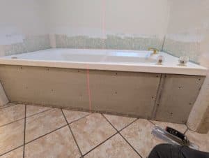 Backerboard installed on tub skirt - tub and floor are out of level, which will make the install tricky