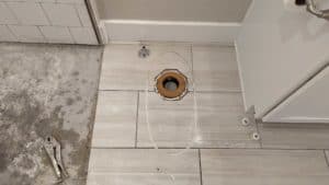 Toilet removed to allow for demo of tiles going up to pan