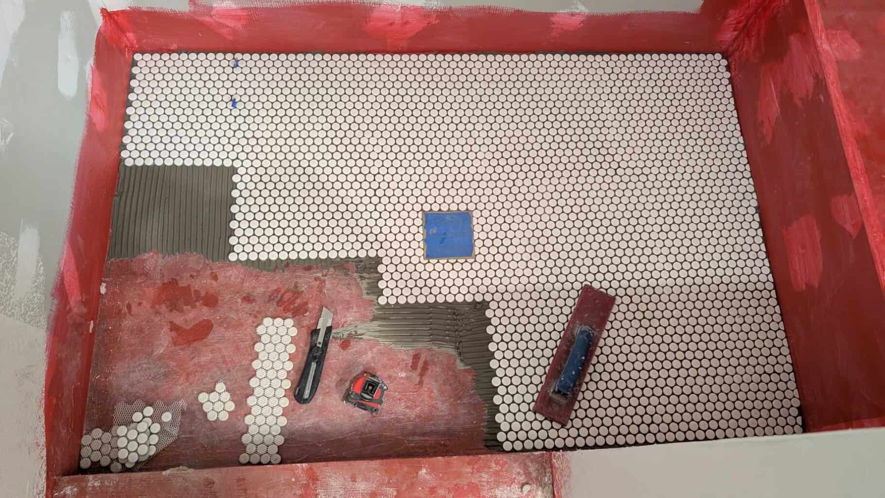 Progress of pennies installled on shower floor