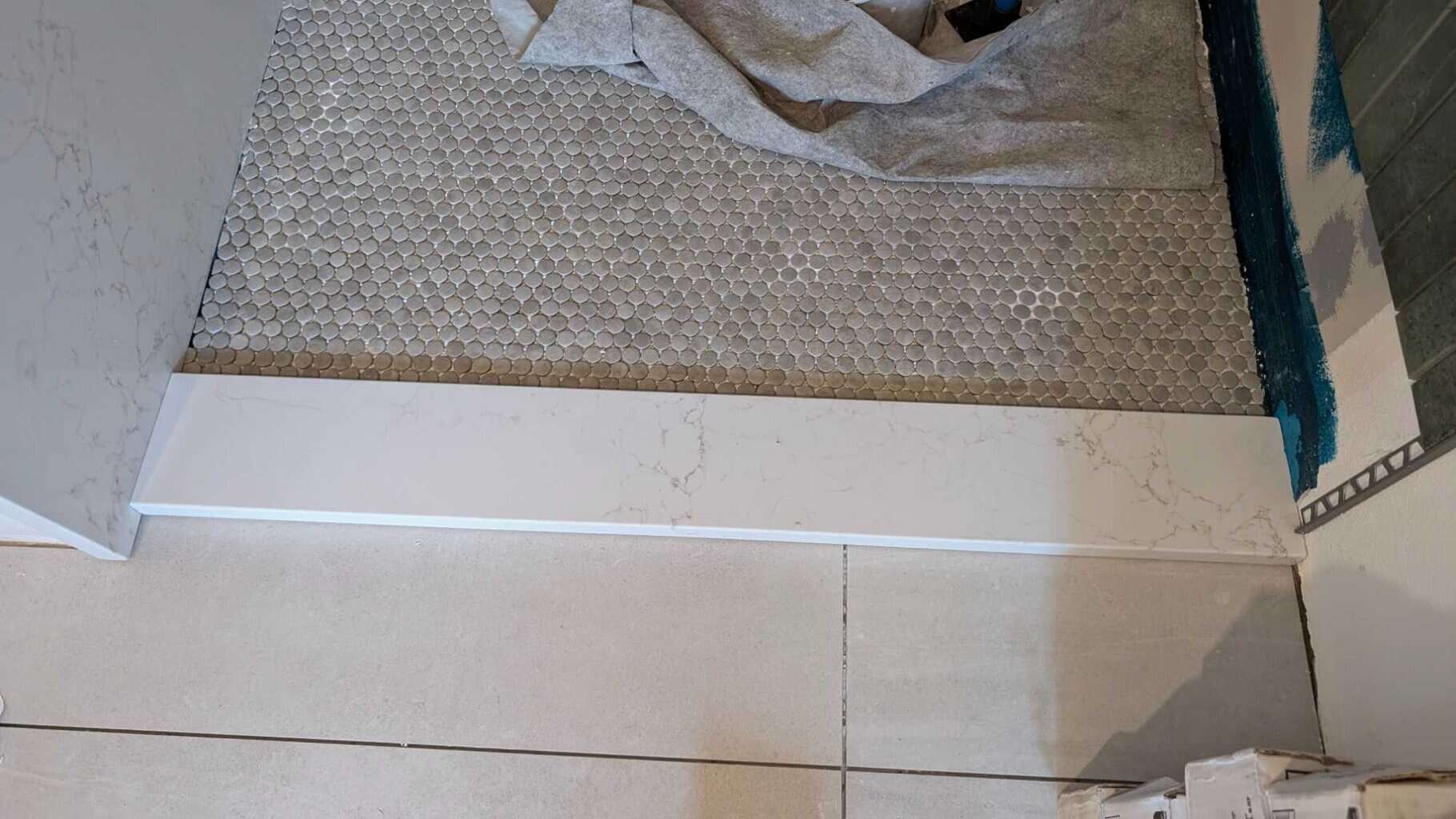 Solid quartz curb installed in primary shower