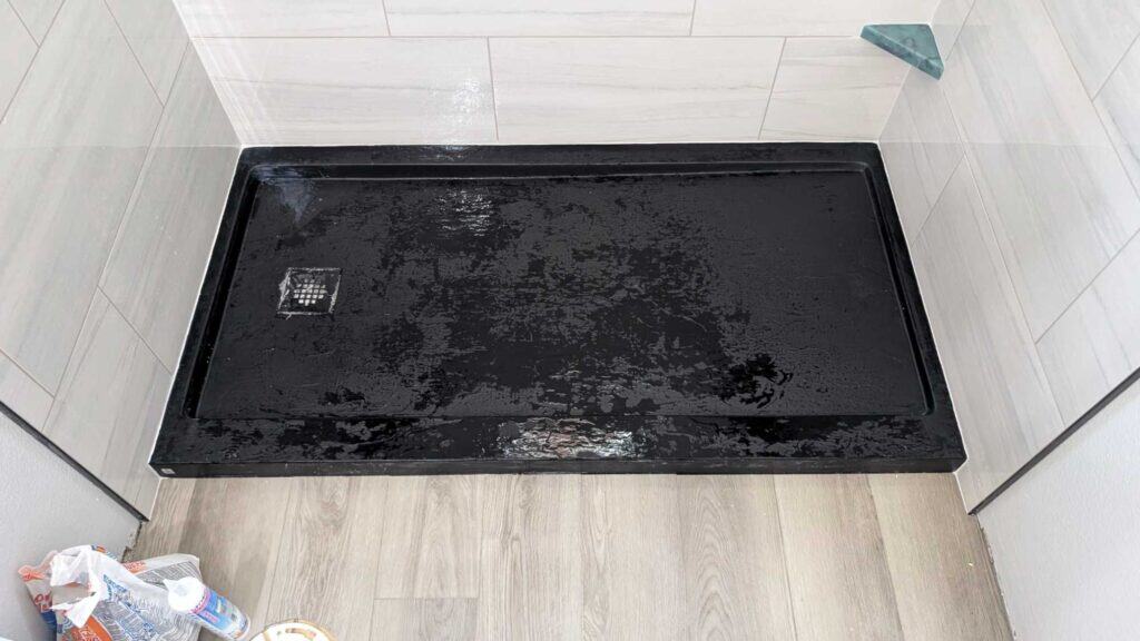 Black textured shower pan and shaving step