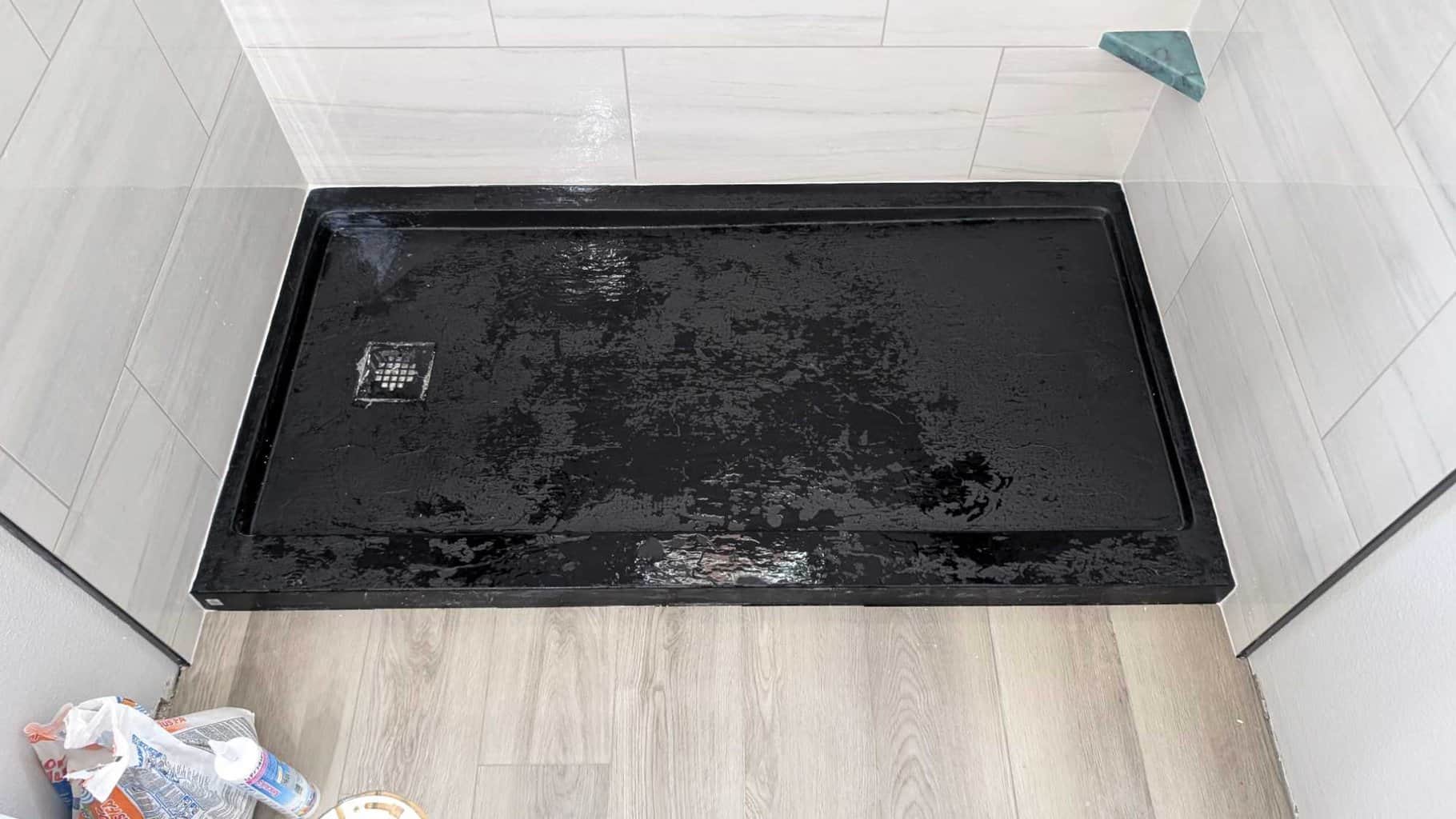 Black textured shower pan and shaving step